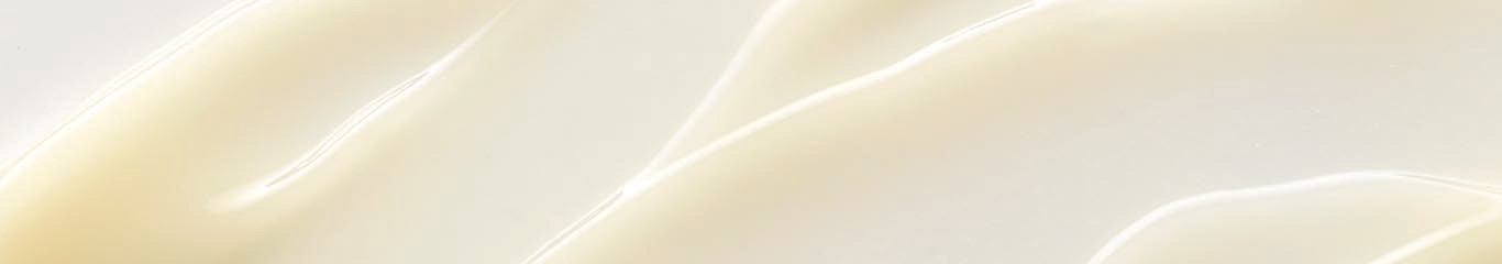 light yellow, sheer, and shiny lotion spread across white background